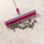 Pet hair removal broom with rubber bristles, pink handle, shown with usage benefits