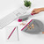 Set of cleaning items including pink and white dustpan and brush, spray bottle, sponge, and bottle in cupboard