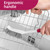 White cleaning brush with ergonomic handle cleaning metal rack in sink