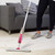 Spray mop with pink and grey handle, shown upright on white background