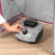 Hand adjusting temperature dial on Kleeneze garment steamer, close-up view of control