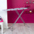 White shirt being ironed on folding ironing board in modern room setting
