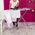 Black and pink steam iron on ironing board, household product listing image