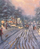 Close up of a puzzle featuring the artwork Hometown Christmas Memories" by Thomas Kinkade, portraying a snowy town at dusk with a man walking his dogs, people strolling with umbrellas, and cars driving down a warmly lit street.