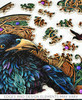 Pieces taken apart of The Celtic Raven wooden jigsaw puzzle showcases a raven in the center, surrounded by Celtic knotwork and adorned with pink and purple gemstones. Edges and design elements may vary.