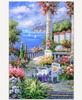From Capri With Love wooden jigsaw puzzle captures a vibrant seaside terrace overflowing with colorful flowers overlooking a sparkling blue sea dotted with white sailboats. A wicker chair and table with drinks sit in the foreground, framed by ivy-draped columns and distant villas nestled in the hills under a lavender sky.