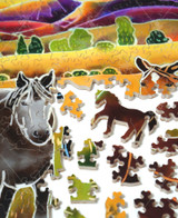  Pieces taken apart from At First Light wooden jigsaw puzzle, introducing a morning scene of horses standing together as they roam about the rolling hills. The sun is starting to rise from behind the purple mountains, allowing sunlight to shine between the clouds. 