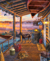  Close up of a peaceful lakeside cabin porch at sunrise overlooks a calm, mist-covered lake glowing with warm golden light. A chocolate lab stands alert on the wooden deck beside vintage fishing gear. 