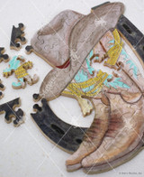  Close-up of Boot Scootin' Good Time wooden jigsaw puzzle showing a cowboy hat sitting on top of a pair of western boots in front of a horseshoe. 
