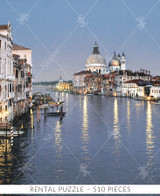  Close-up of Evening In Venice wooden jigsaw puzzle, bringing viewers to the canals of Italy, where lights from the surrounding architecture reflect off the calm water. Boats are parked at the docks as three gondolas float down the canal before the evening sky grows darker. 