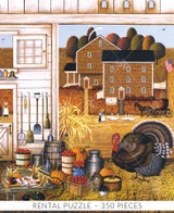  Close-up of Turkey In The Straw wooden jigsaw puzzle displaying a turkey standing inside a barn next to buckets of apples, pumpkins, a milk jug, and burlap sacks of grain. The open hay door leads out to a dirt road with a house and corn field across the road. A lady herds her geese down the road. 