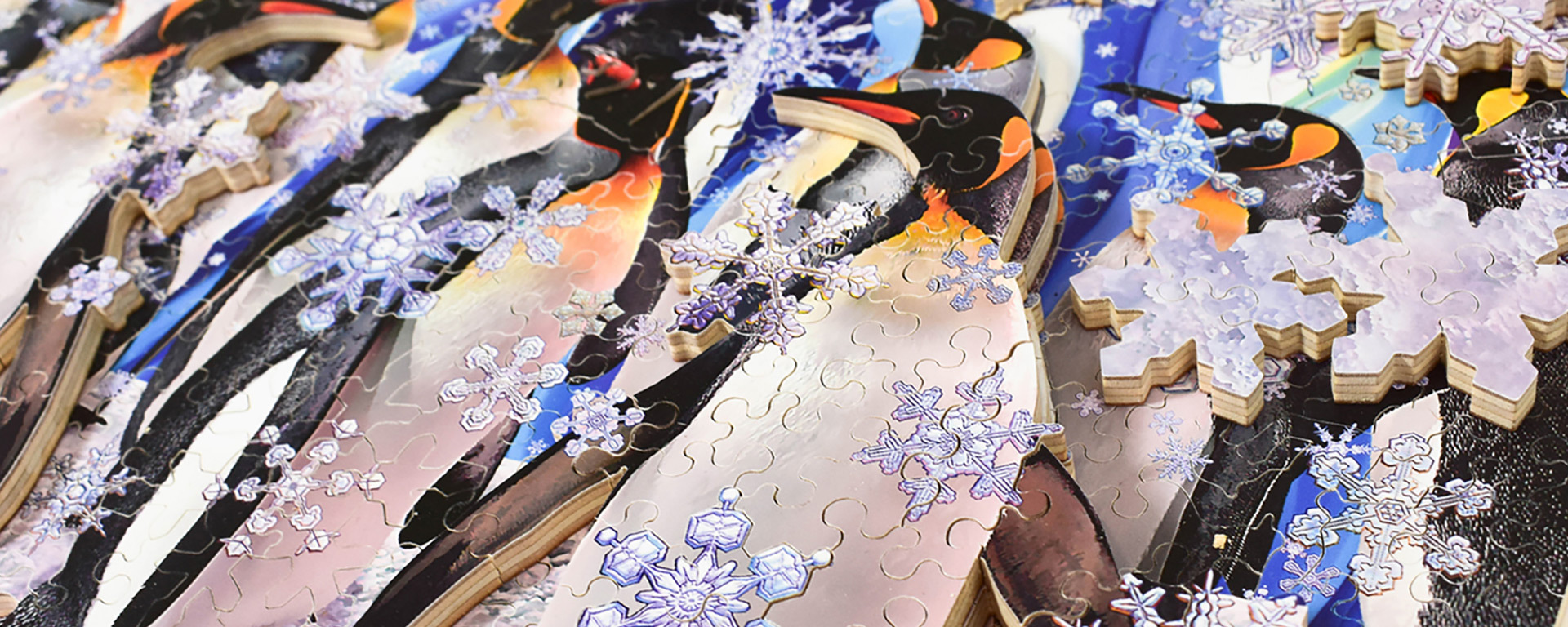 Wooden artic animal jigsaw puzzle featuring snowflake shaped pieces and artic penguins.