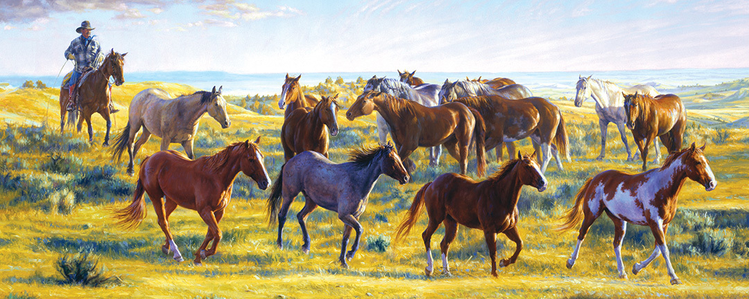 cowboy on horseback with a group of horses trying to rope one