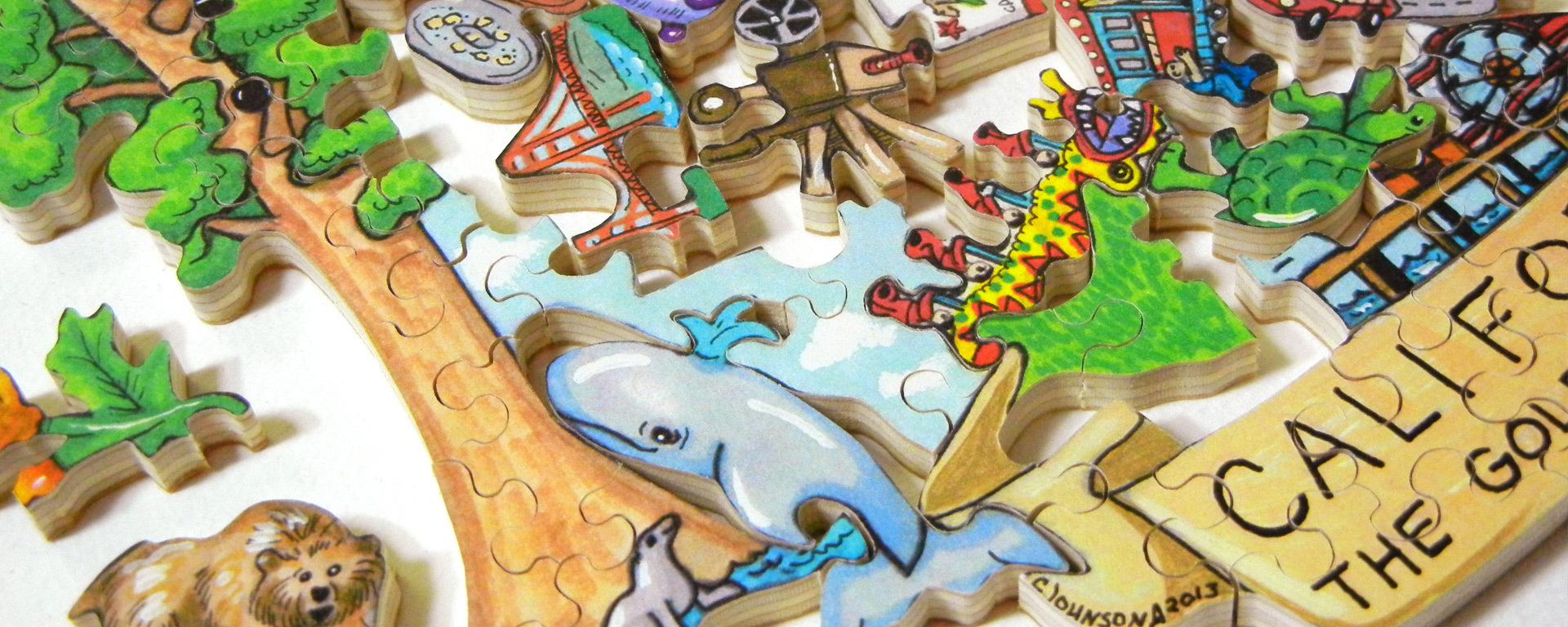Wooden US state puzzle in progress of a Californian scene featuring a whale, tree, and turtles.