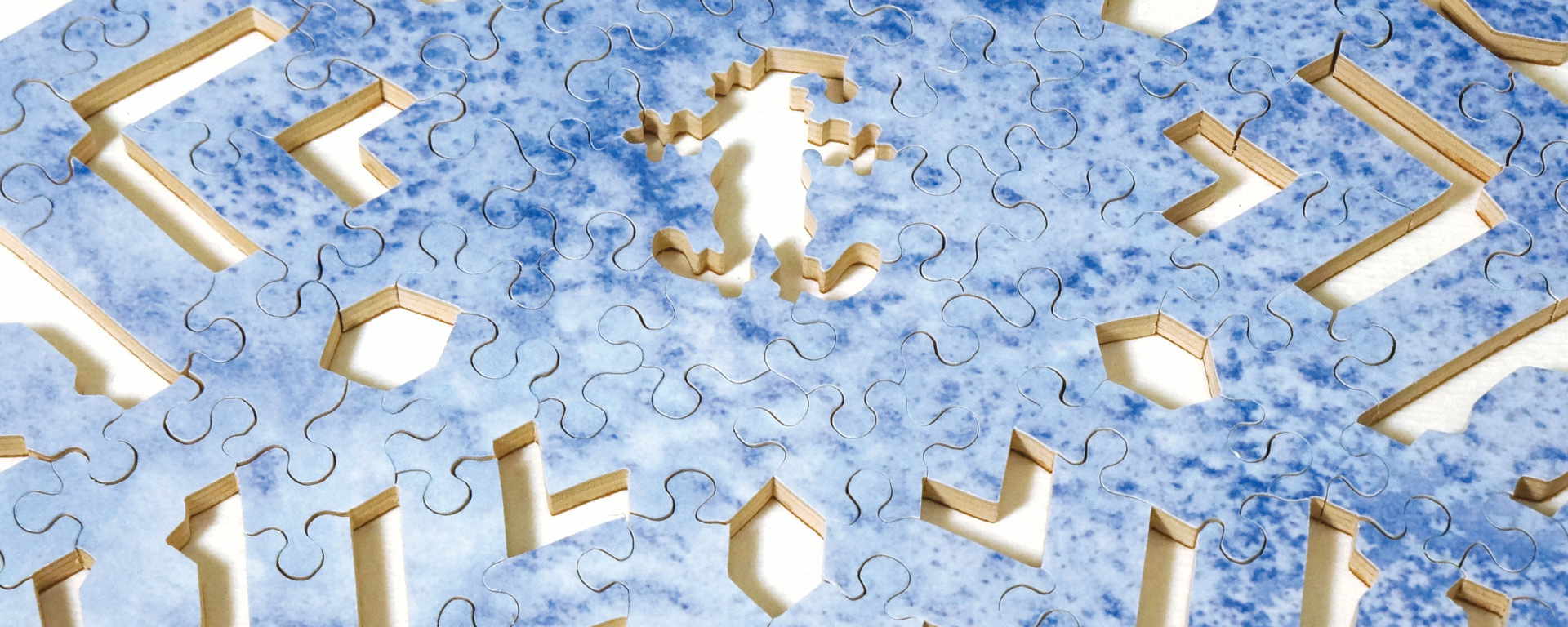 Wooden snowflake puzzle showing various shades of blue creating an intricately designed snowflake.