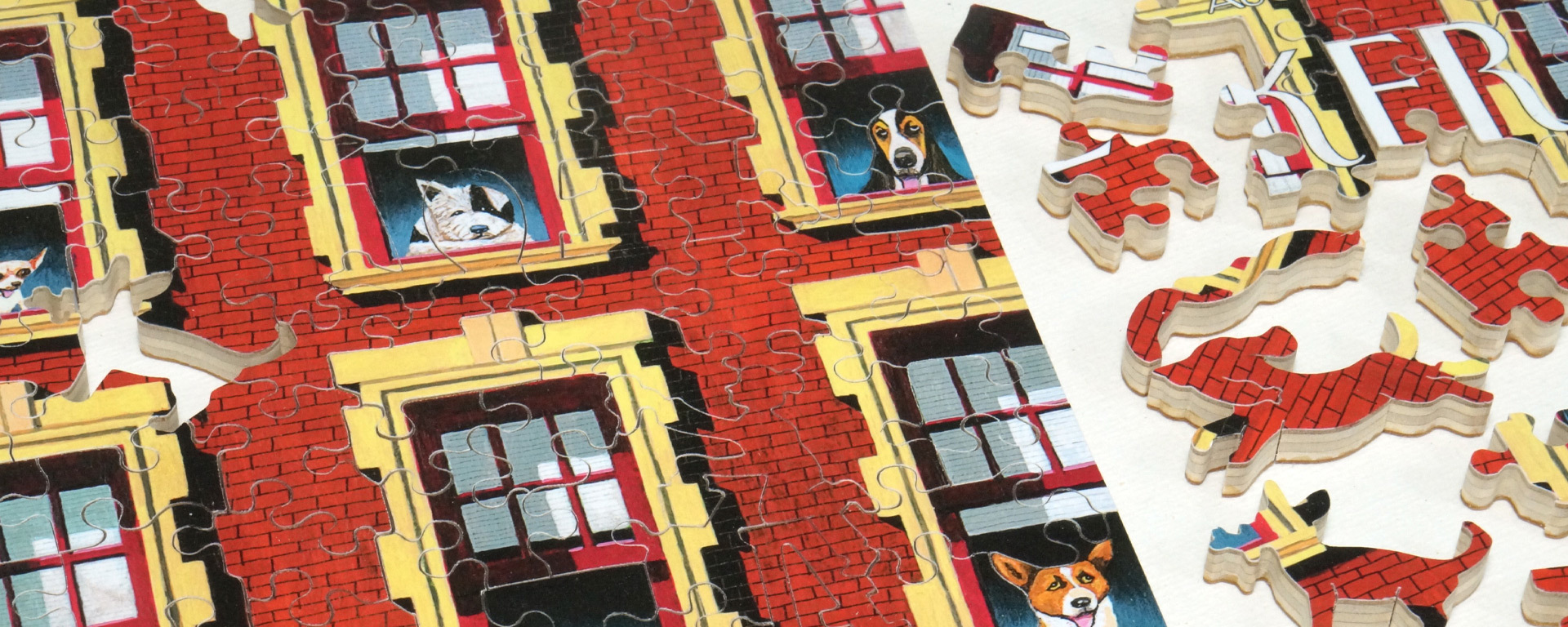 Wooden New Yorker cover art puzzle in progress featuring an red apartment building with a different type of dog in each yellow framed open window.