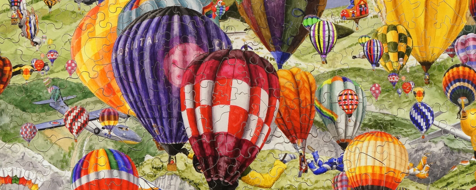 Wooden hot air balloon puzzle featuring a bunch of brightly colored hot air balloons, sky divers, and a plane.