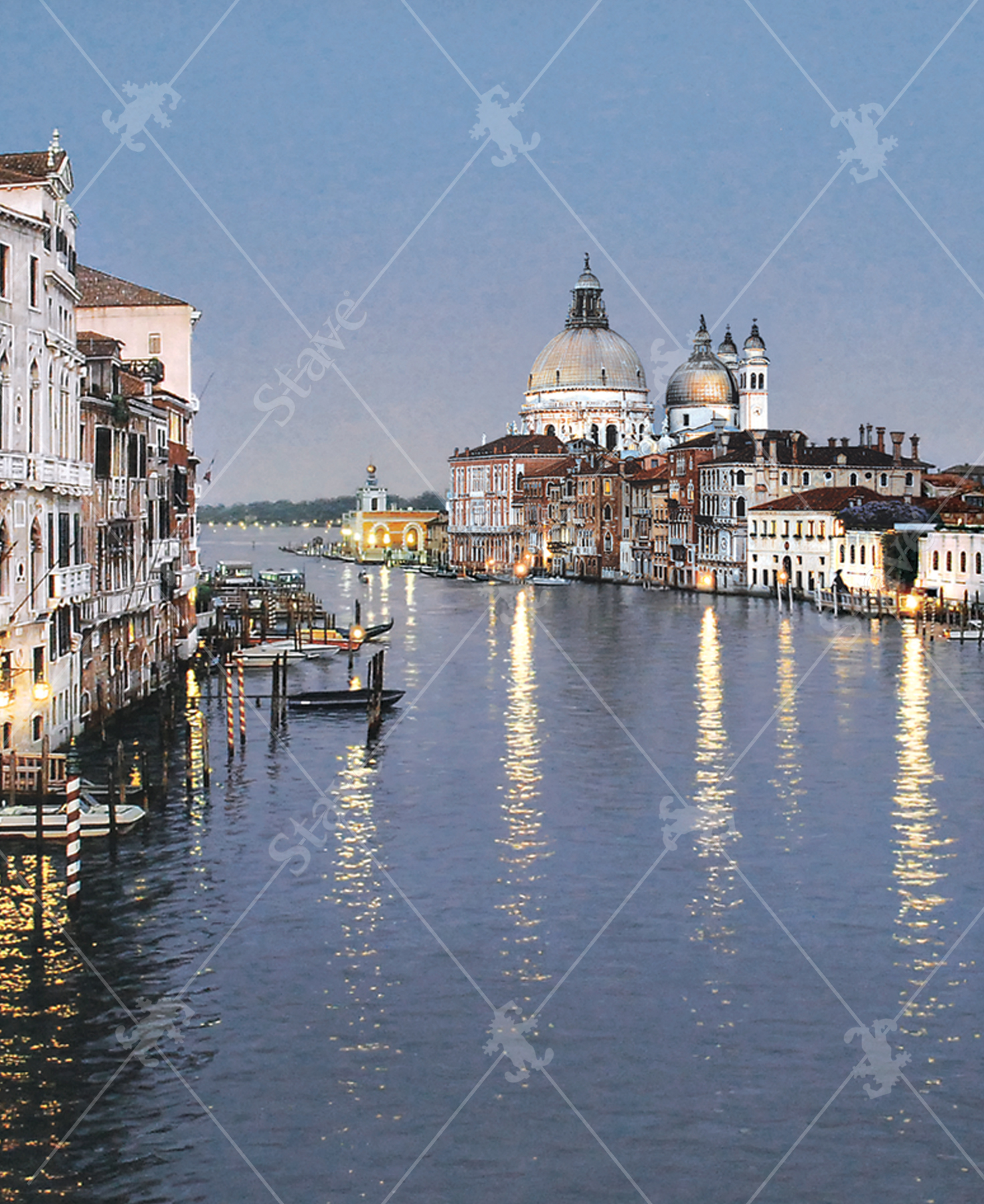 Close-up of Evening In Venice wooden jigsaw puzzle, bringing viewers to the canals of Italy, where lights from the surrounding architecture reflect off the calm water. Boats are parked at the docks as three gondolas float down the canal before the evening sky grows darker.