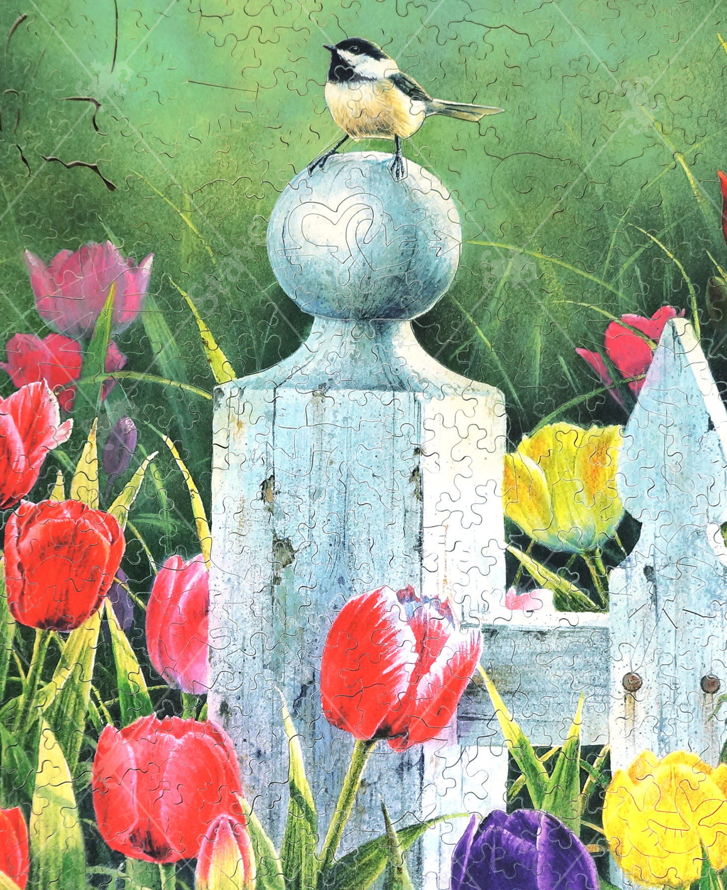 Cut version of Picket Fence Bouquet wooden jigsaw puzzle featuring a chickadee sitting on a picket fence in a flower garden of tulips.