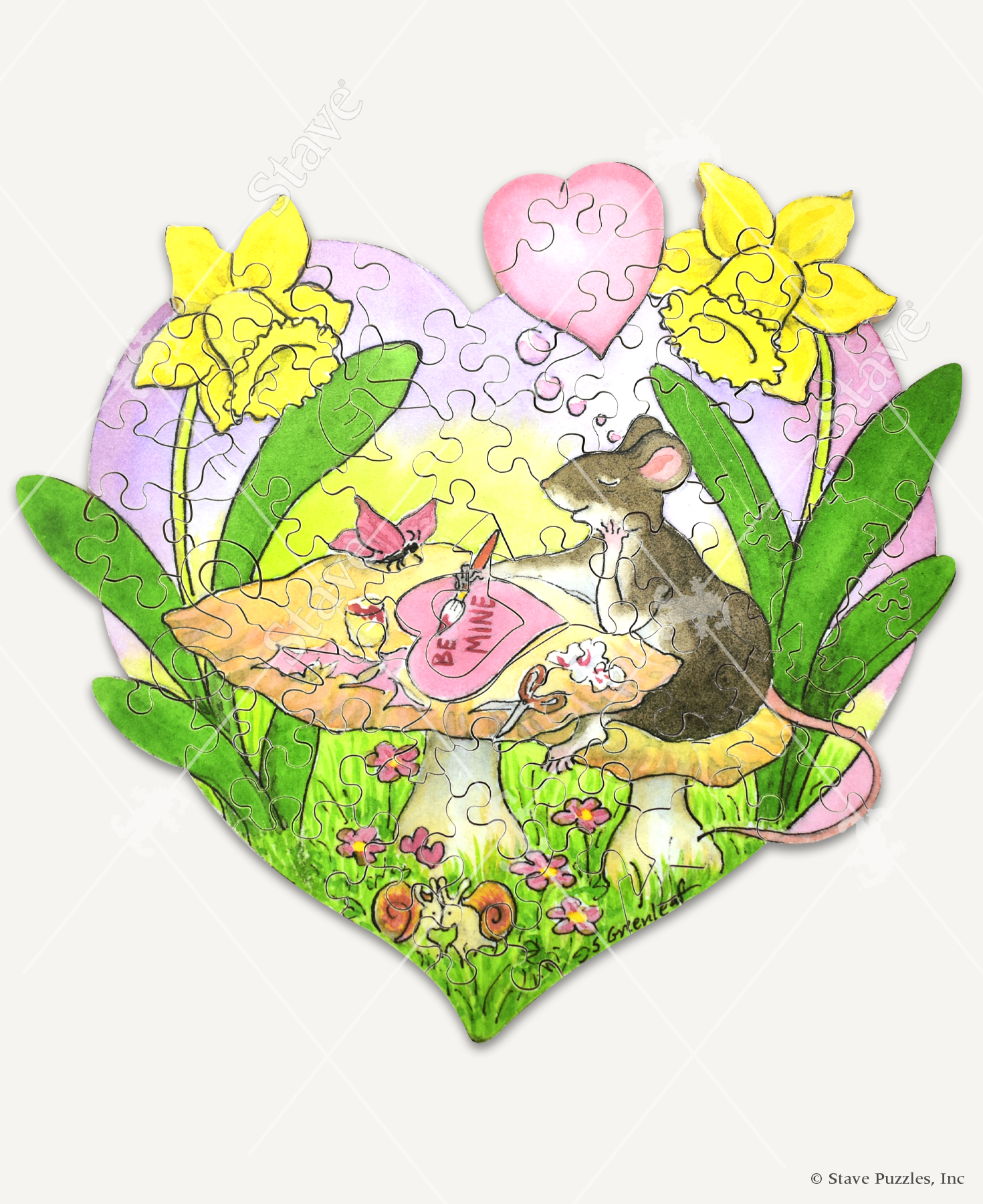 Hearts And Crafts wooden jigsaw puzzle features a mouse sitting at a mushroom table, who is joined by a butterfly as it crafts a heart shaped valentine's day card and paints the words "be mine". The mouse is thinking about love, which is depicted with a pink heart shaped thought bubble above the mouse's head. This scene is enclosed inside a giant heart shape and framed with a daffodils on each side of the image. Towards the bottom on the heart, two snails sit in the grass and embrace each other as their tails form a heart.