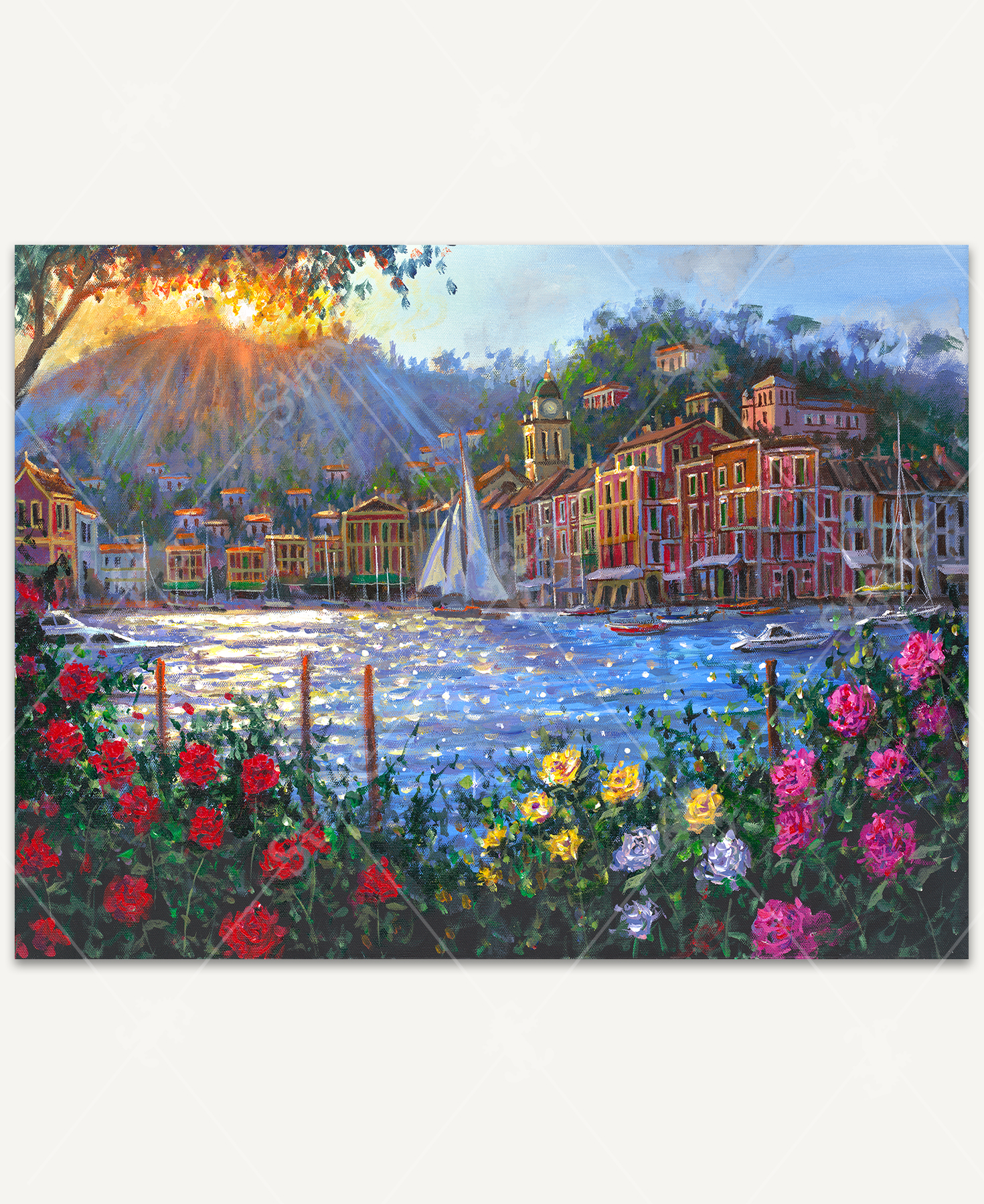 Portofino Reverie wooden jigsaw puzzle captures the view of boats floating in the water off the coast, with a sail boat right in the center. Buildings follow along the shoreline and find their way up the mountain, where the sun can be seen setting. In the foreground, colorful flower bushes add bright colors and frames the bottom of the scene.