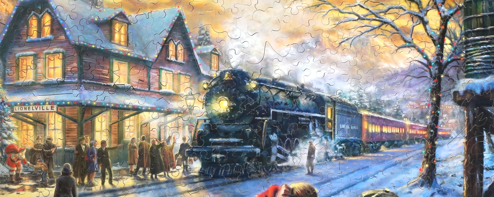 Wooden jigsaw Christmas landscapes puzzle illustrating a train pulling up to the Lionelville station in the winter.