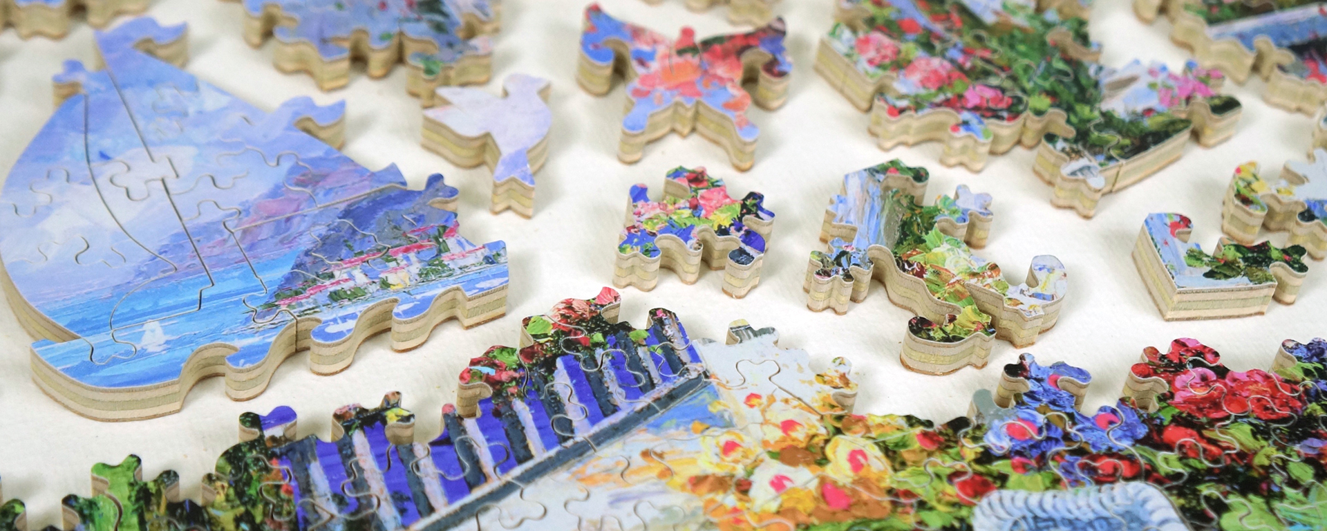 Wooden Mediterranean puzzle in progress showing whimsy shaped pieces such as a sailboat, dove, butterfly, and the Stave logo.