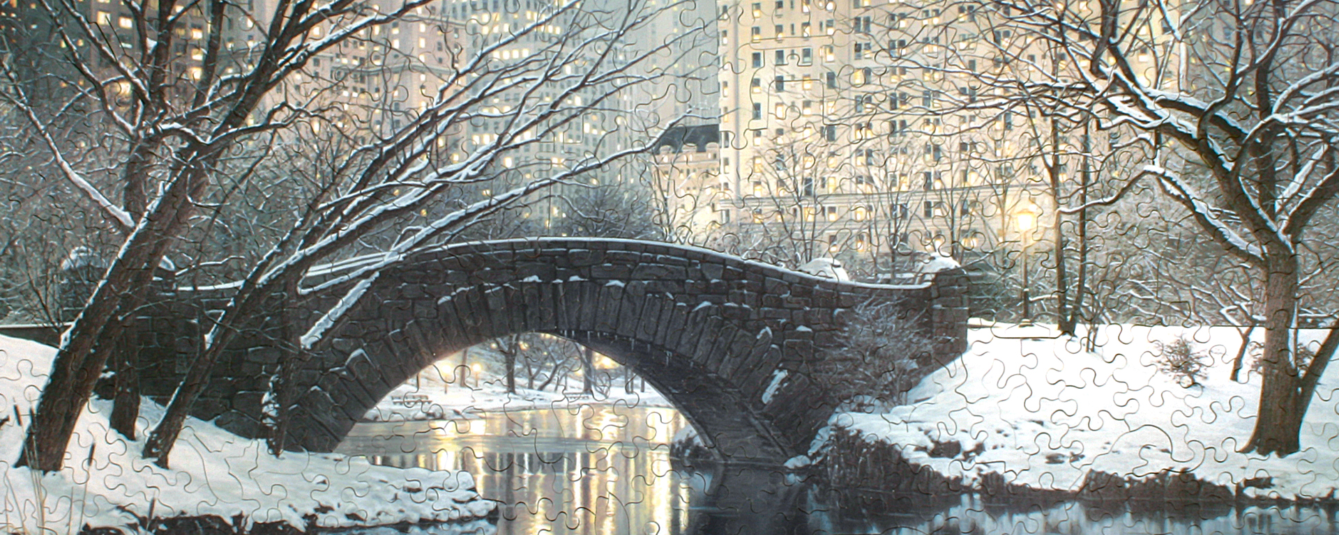 Wooden winter landscapes puzzle featuring a snow covered stone bridge in Central Park at twlight.