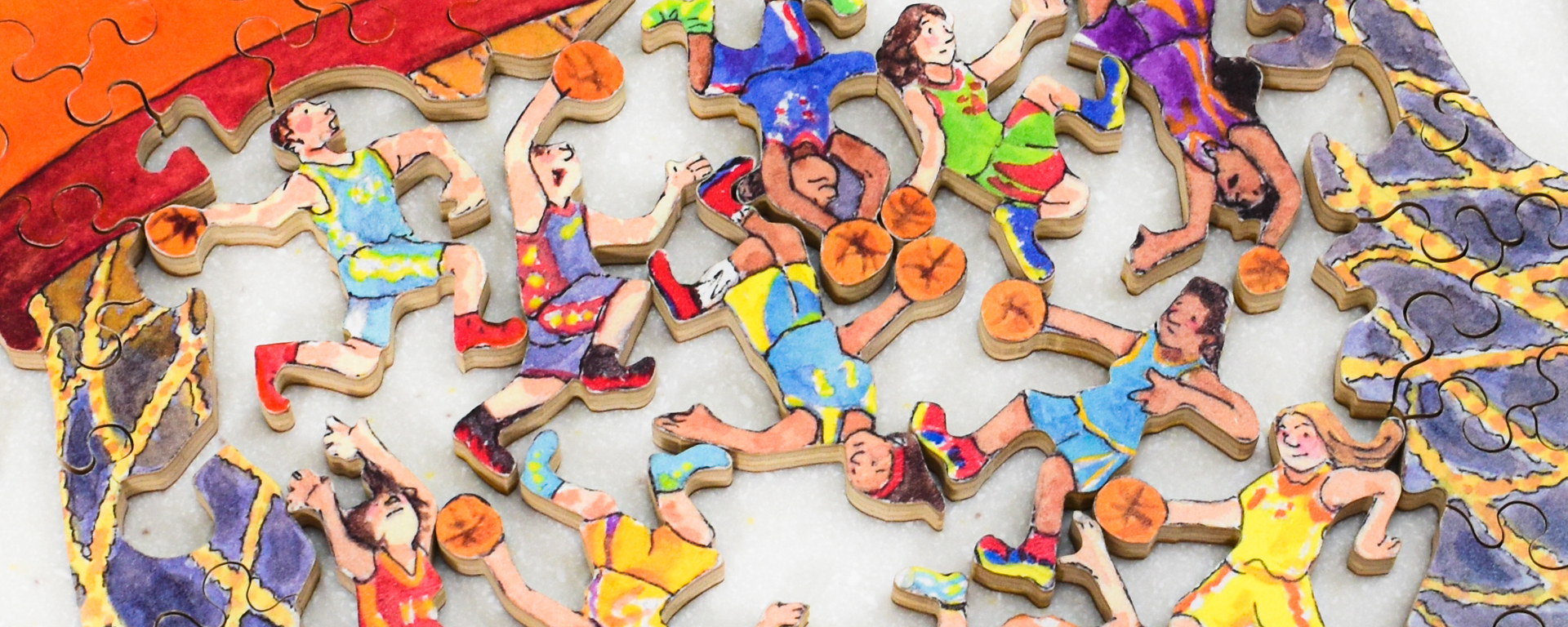 Wooden basketball puzzle in progress with whimsy shaped pieces shaped like baseball players.