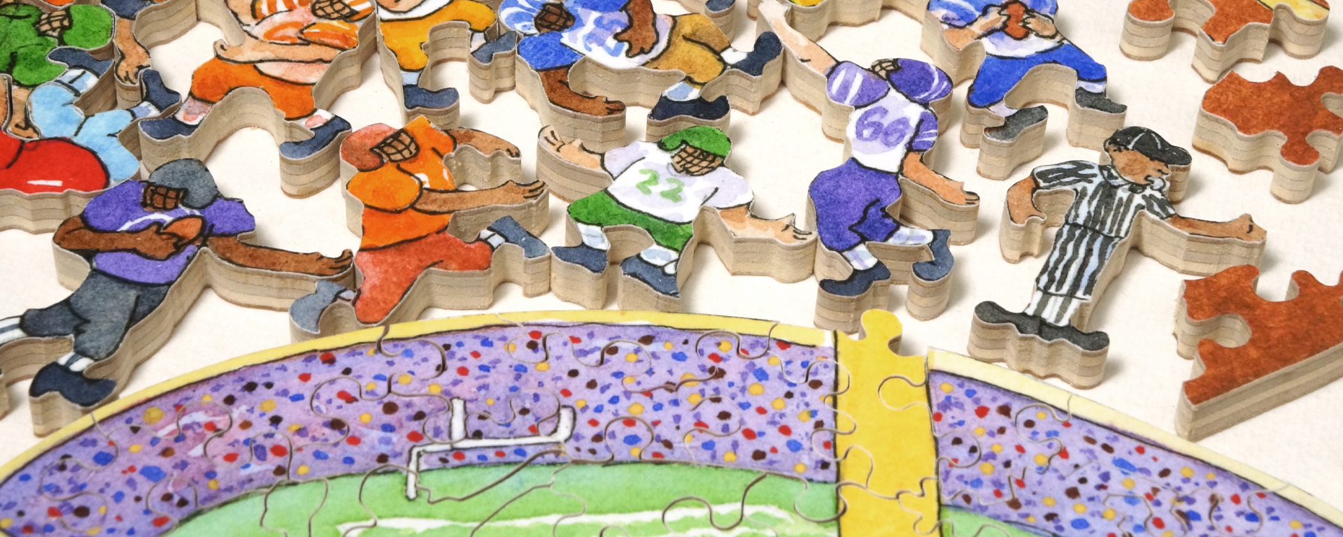 Wooden football puzzle in progress with whimsy shaped pieces shaped like football players with a stadium in the foreground.