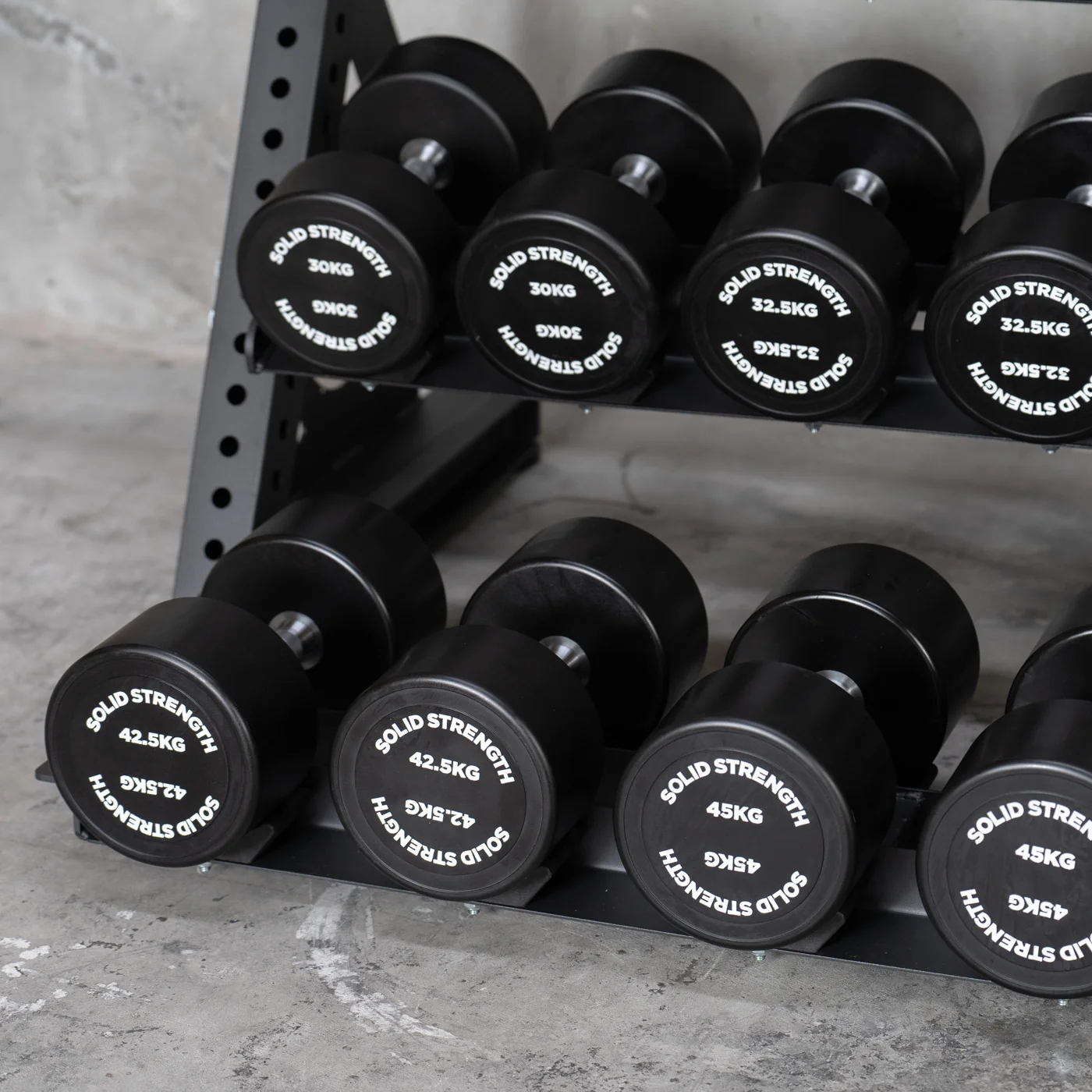 Solid Strength rubber hex dumbbells on a storage rack