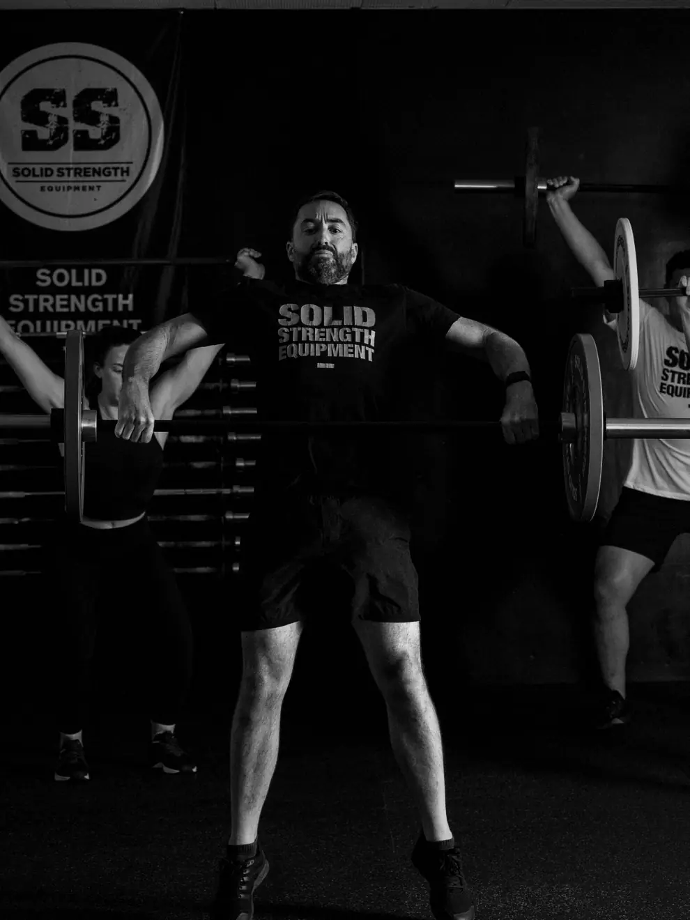 A group barbell class training on Solid Strength equipment