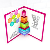 Inside of a handmade greeting card with cake on it and wishing you a birthday piled high with happiness sentiment on it.