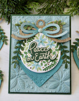 Handmade greeting card with ornament on it and peace on earth sentiment on it.
