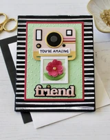 Handmade greeting card with polaroid on it and a photo of a flower with you're amazing, friend sentiment on it.