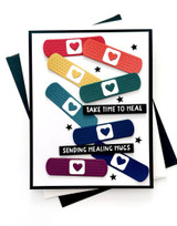 Handmade greeting card with bandaids on it and take time to heal, sending healing hugs sentiment on it.