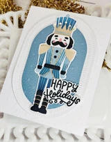 Handmade greeting card with nutcracker on it and happy holidays sentiment on it.