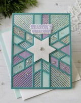 Handmade greeting card with snowflake pattern on it and season's greetings sentiment on it.
