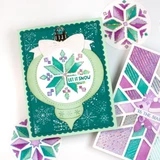 Handmade greeting card with ornament on it and a pattern with let it snow sentiment on it.