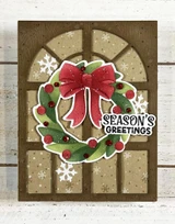 Handmade greeting card with wreath on it and season's greetings sentiment on it.