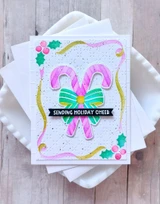 Handmade greeting card with candy canes on it and sending holiday cheer sentiment on it.