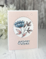 Handmade greeting card with flowers in the center and birthday wishes sentiment on it.
