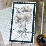 Handmade greeting card with flowers on it and love you sentiment on it with crafting materials in background.
