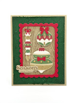 Handmade greeting card with ornaments on it and season's greetings sentiment on it.