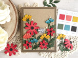 Handmade greeting card with flowers on it and miss you sentiment on it with crafting materials in background.