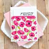 Handmade greeting card with flowers on it and praying for you sentiment on it with cardstock in background.