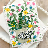 Handmade greeting card with flower son it and get well soon sentiment on it with cardstock in background.
