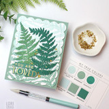 Handmade greeting card with two ferns on it with you are loved sentiment on it with color palette in background.