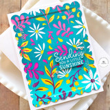 Handmade greeting card with flowers on it and sending you a little sunshine sentiment on it with cardstock in background.