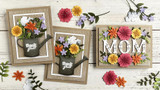 Three handmade greeting cards, two that have flowers in a watering can that has thank you sentiment on it and one with mom sentiment on it.